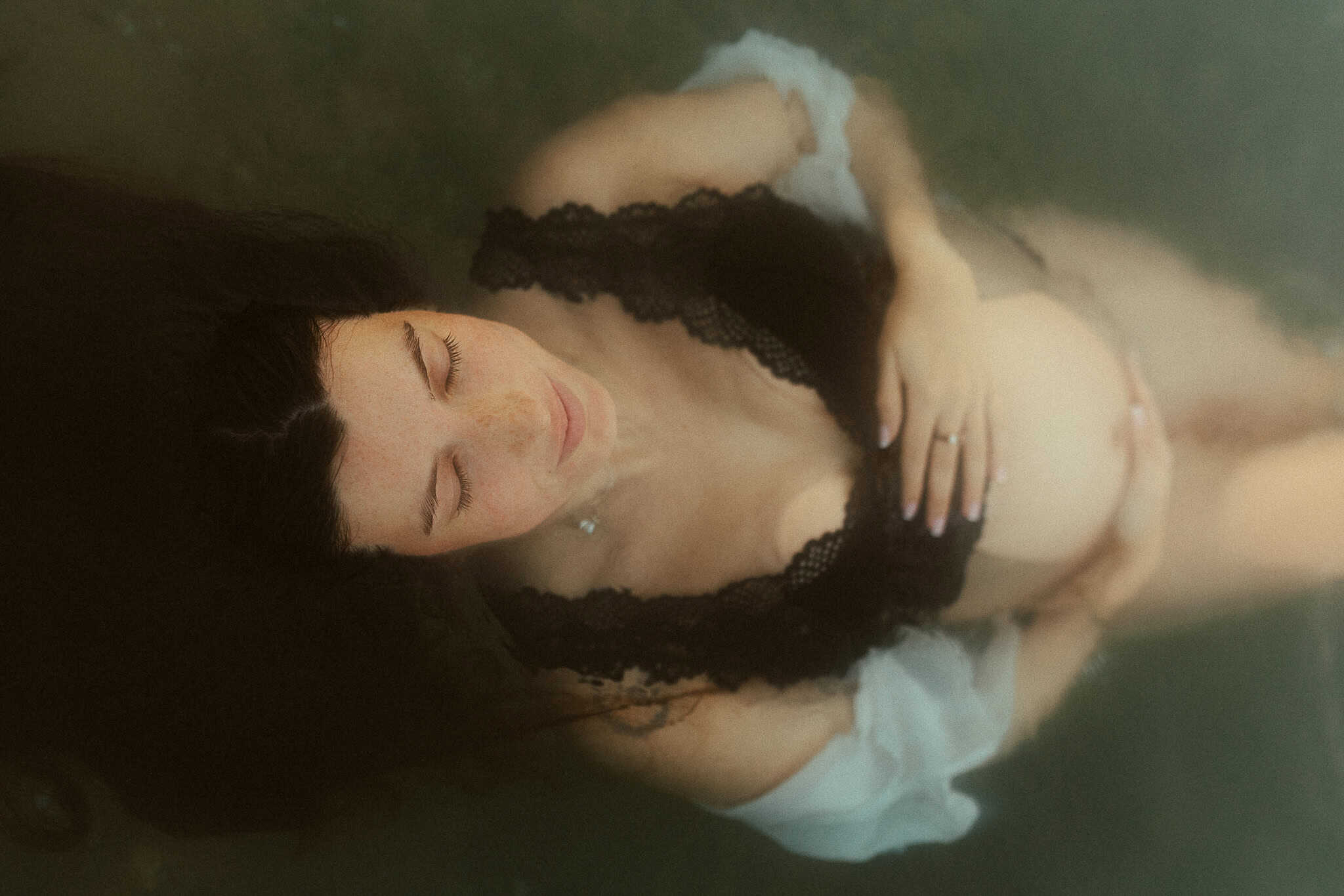 maternity photoshoot floating in the sea